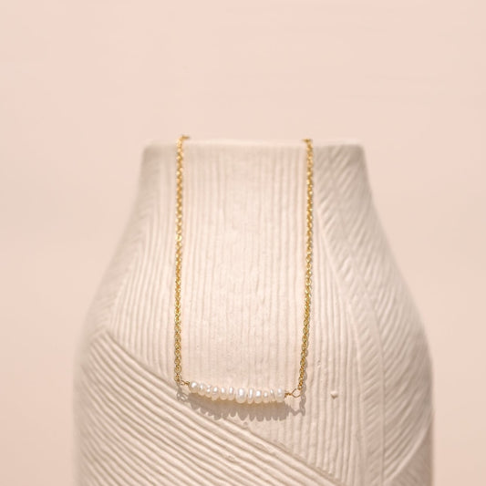 Collier "Seek" composé de perles d'eau blanche imparfaite, monté sur une chaine fine forçat le tout doré à l'or fin.
