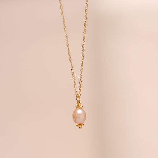 Collier "Faith" composé d'une perle de culture saumon ou blanche monté sur une chaine fine torsadé le tout doré à l'or fin (ici version saumon).