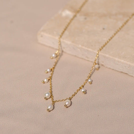 Collier "Patience" composé de perles d'eau blanche monté sur une chaine forçat le tout doré à l'or fin.
