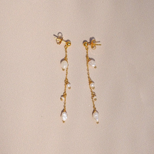 Boucles d'oreilles "Encourage" composé de deux puces d'oreilles agrémentés de perles d'eau sur une chaine forçat, le tout doré à l'or fin.